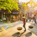 The Old Quarter A vendor is walking into old street Hanoi Vietnam